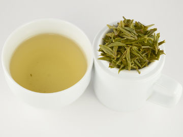شاي أخضر عضوي محفوظ برائحة شاي التنين مع شكل منحني من ورق الشاي الطازج